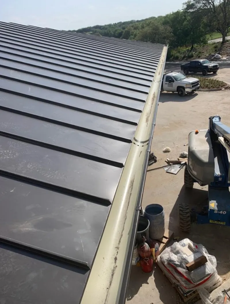 Standing seam panel and gutter detail on a metal roofing jobsite in Ione